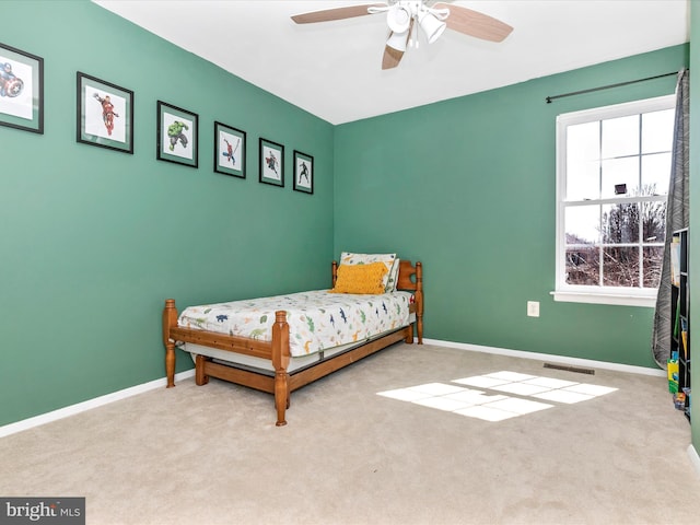 bedroom featuring visible vents, baseboards, carpet, and a ceiling fan