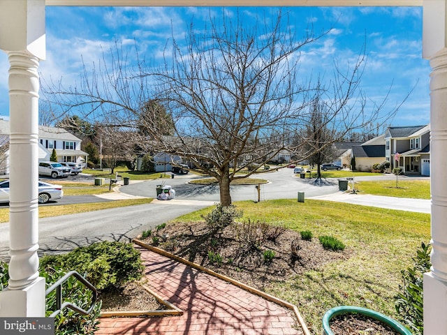 view of yard featuring a residential view and covered porch