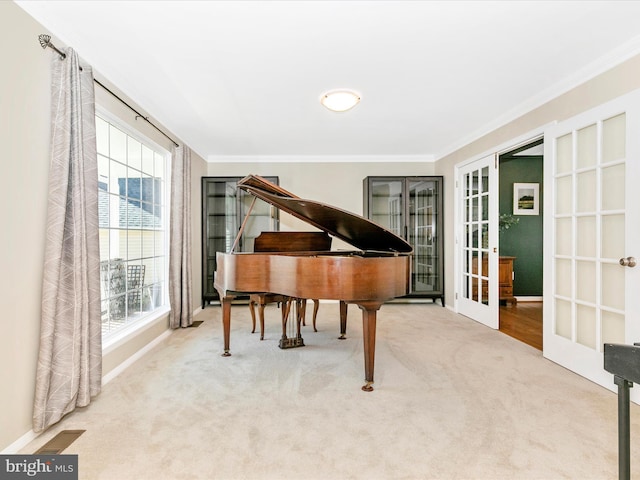 living area featuring french doors, visible vents, carpet floors, and ornamental molding