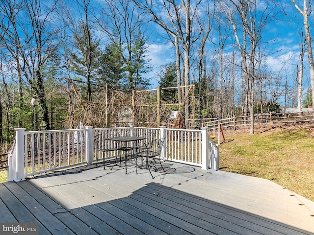 wooden terrace featuring a lawn