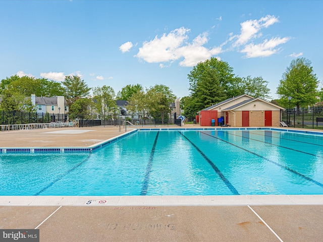 community pool featuring a patio and fence