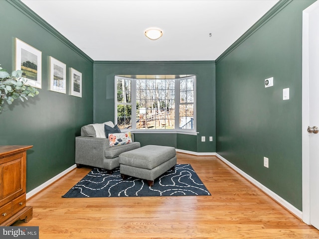 sitting room featuring crown molding, baseboards, and wood finished floors