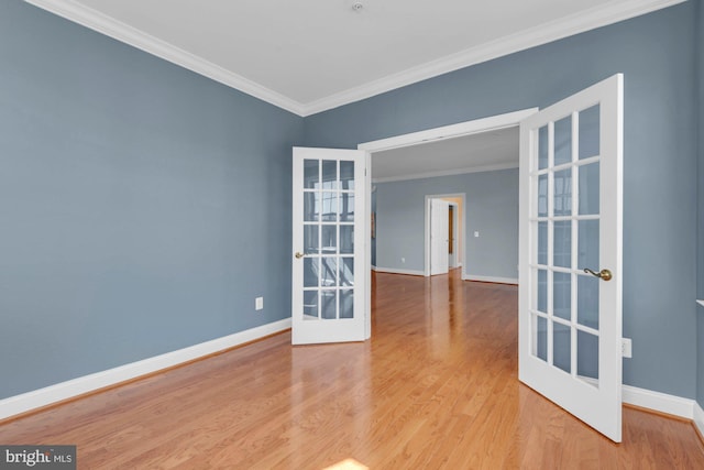 spare room featuring ornamental molding, french doors, baseboards, and wood finished floors