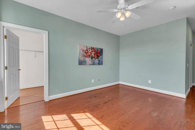 unfurnished room featuring a ceiling fan, baseboards, and wood finished floors