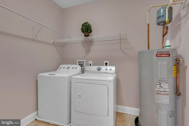 clothes washing area featuring laundry area, separate washer and dryer, baseboards, and electric water heater