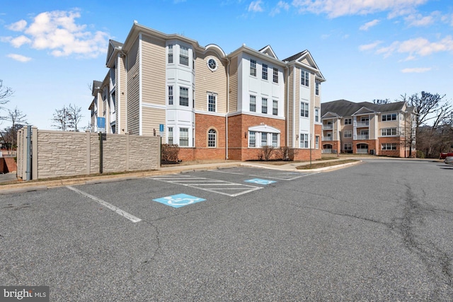 view of property with uncovered parking and fence