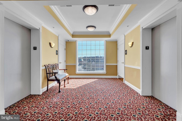 living area with a tray ceiling, elevator, carpet, and ornamental molding