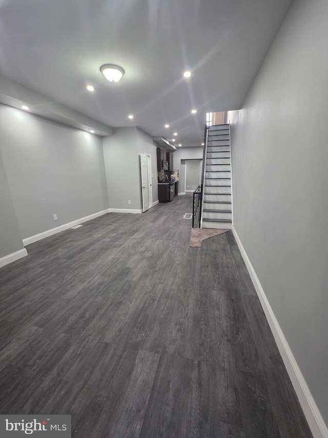 below grade area with recessed lighting, stairway, baseboards, and dark wood-type flooring