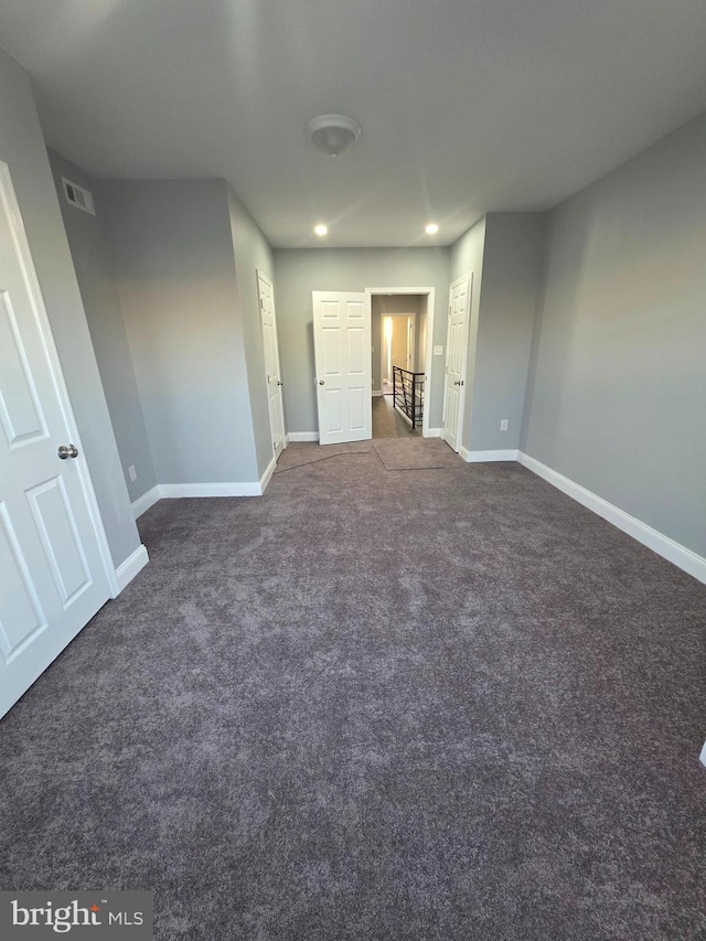 unfurnished bedroom with recessed lighting, visible vents, baseboards, and dark carpet