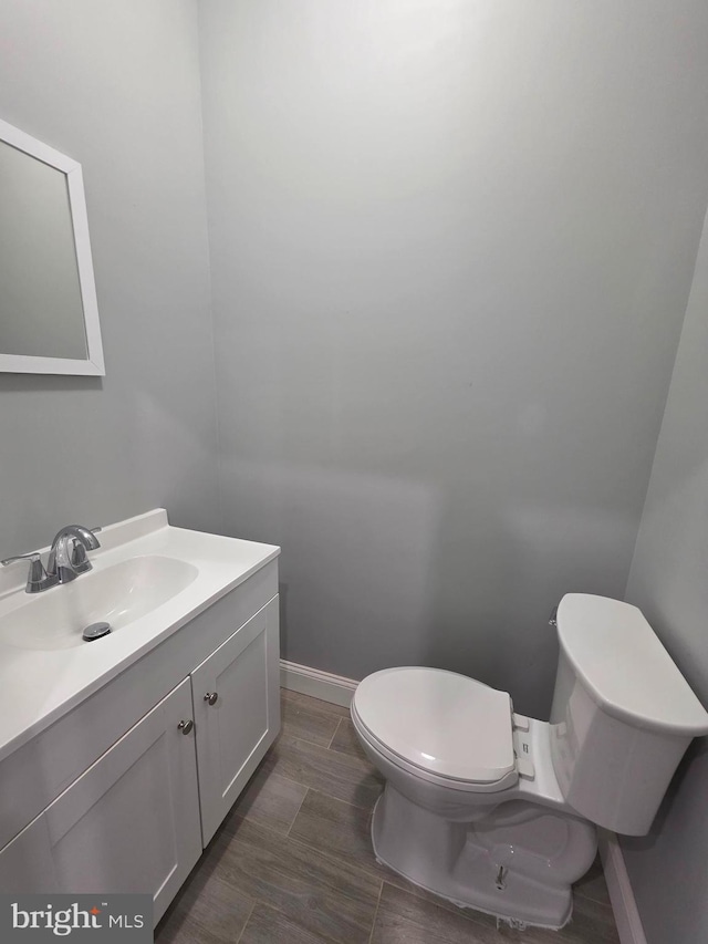 bathroom featuring vanity, toilet, and baseboards