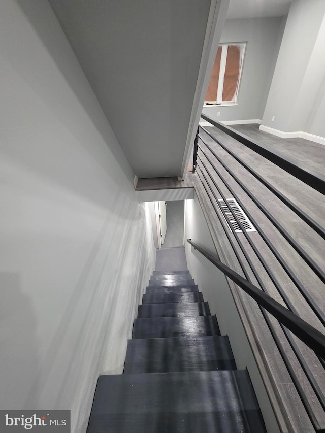 staircase with baseboards and wood finished floors