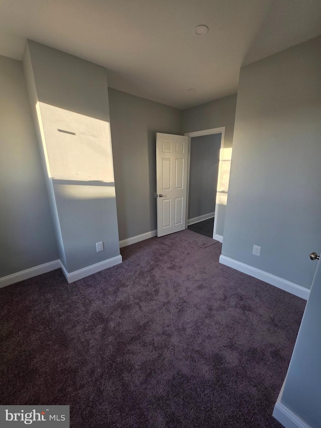 unfurnished bedroom with carpet flooring and baseboards