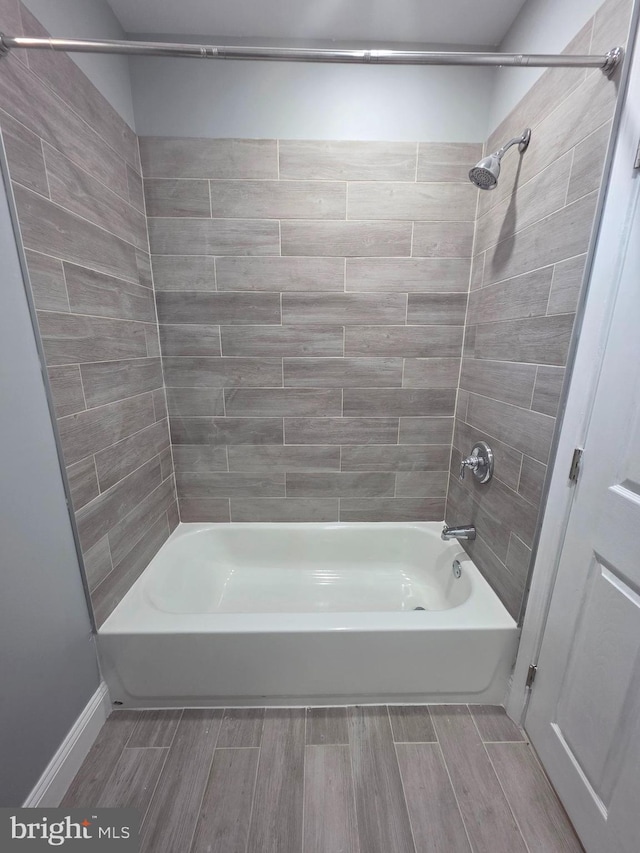 full bath with wood finish floors and shower / tub combination