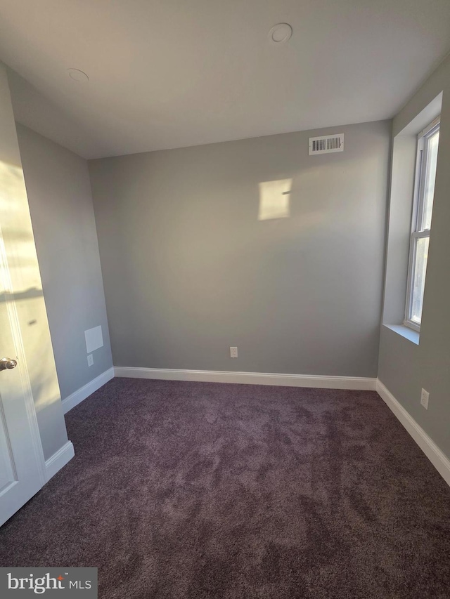 unfurnished room with visible vents, baseboards, and carpet