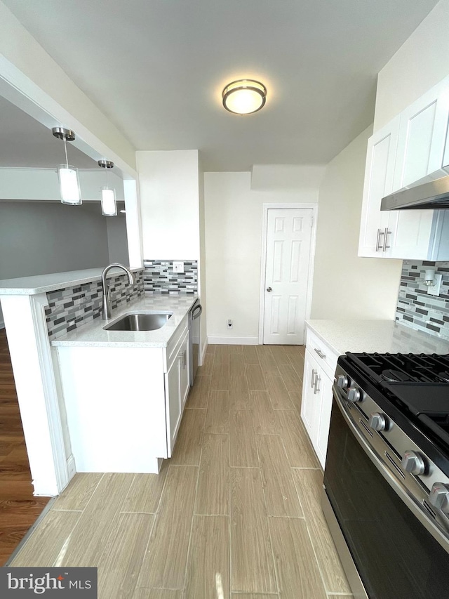 kitchen featuring a sink, tasteful backsplash, appliances with stainless steel finishes, and white cabinetry