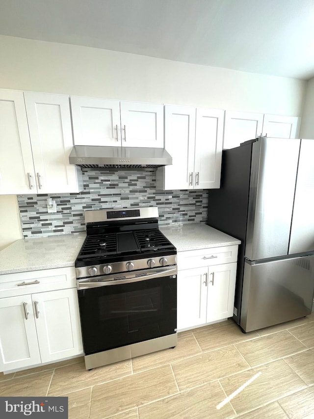 kitchen featuring under cabinet range hood, stainless steel appliances, tasteful backsplash, and white cabinetry