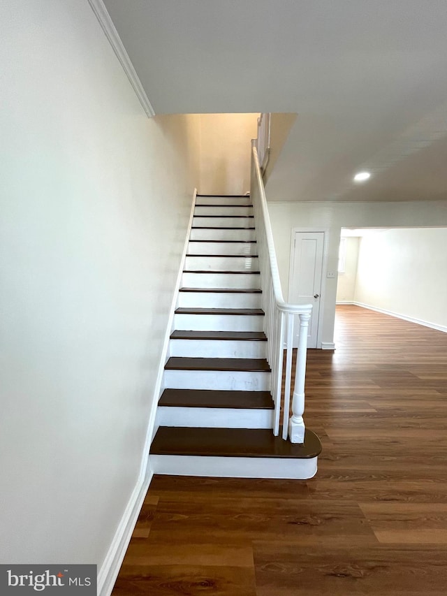 stairway with crown molding, recessed lighting, wood finished floors, and baseboards