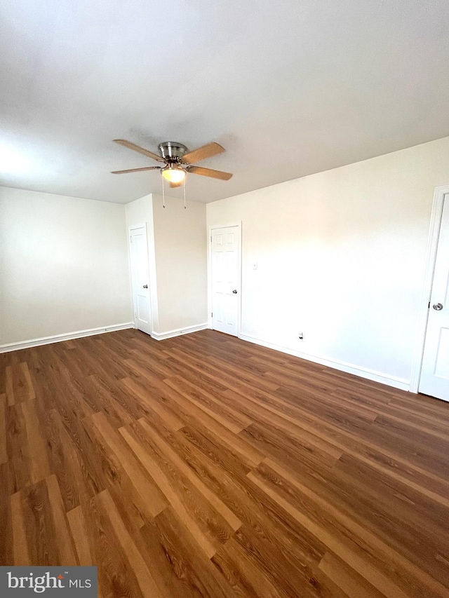 spare room with baseboards, wood finished floors, and a ceiling fan