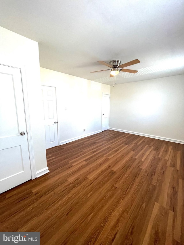 unfurnished room featuring baseboards, a ceiling fan, and dark wood-style flooring