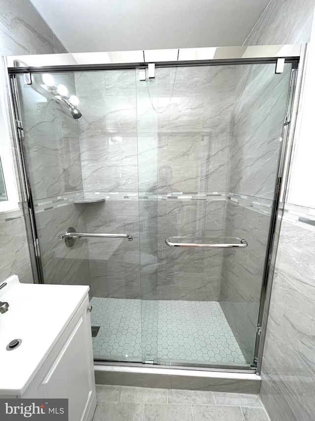 full bath with a stall shower and vanity