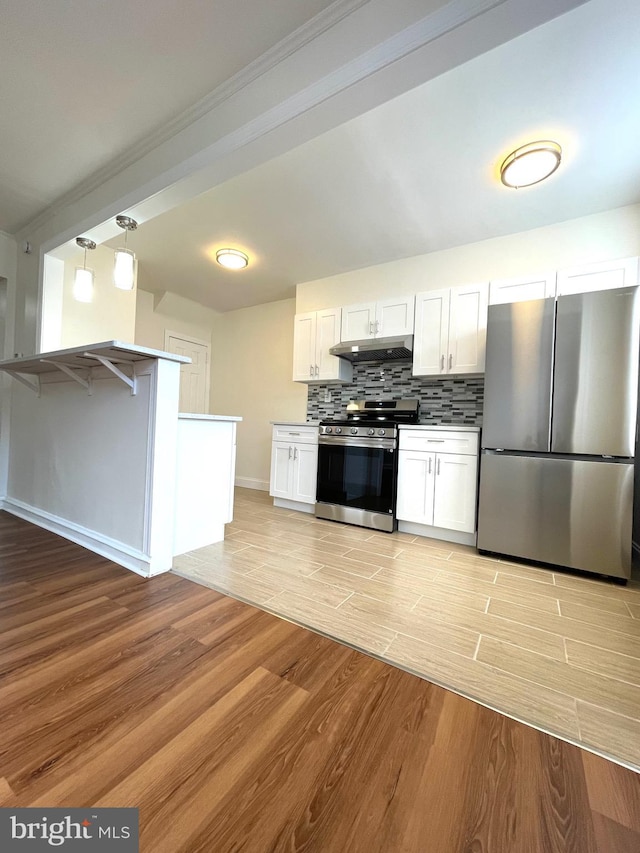 kitchen featuring under cabinet range hood, backsplash, appliances with stainless steel finishes, and light wood-style flooring