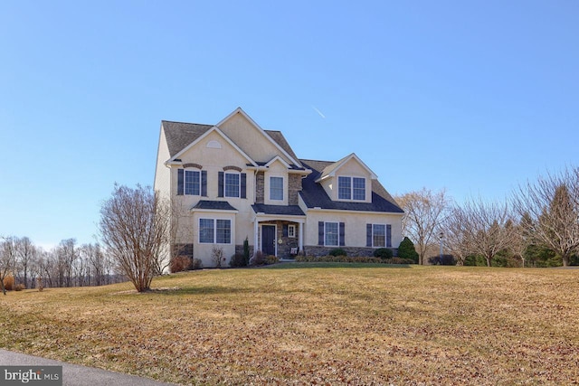 traditional-style home featuring stone siding and a front yard