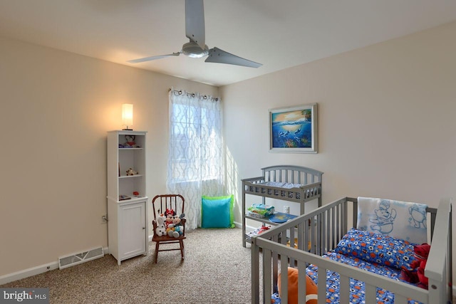 bedroom featuring a nursery area, visible vents, baseboards, and carpet