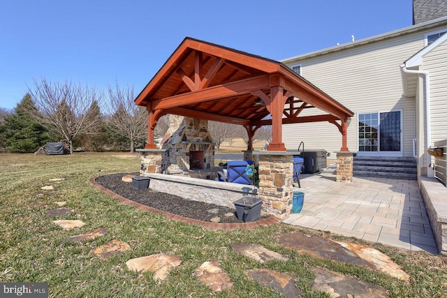 view of patio / terrace featuring entry steps, a gazebo, and an outdoor stone fireplace