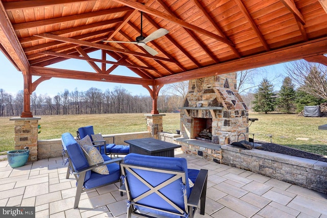 view of patio / terrace featuring a gazebo and an outdoor stone fireplace