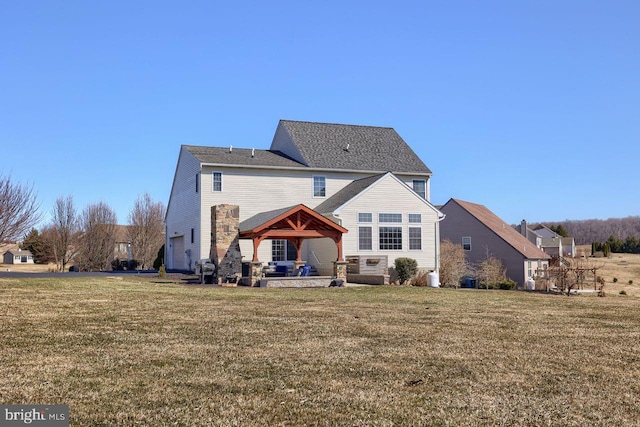 back of property featuring a gazebo, a garage, a lawn, and a patio