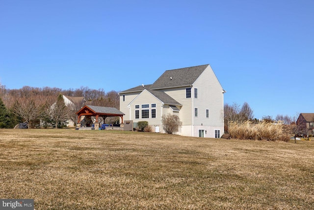 back of property featuring a gazebo and a yard