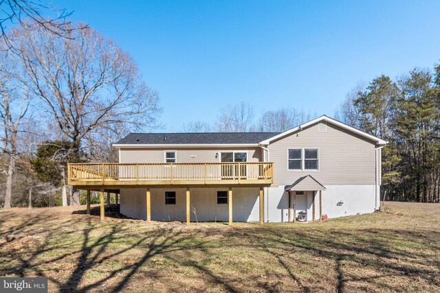 rear view of property with a deck and a yard