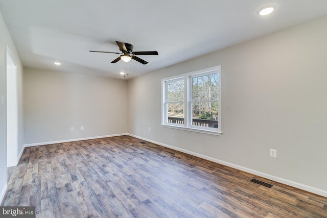 spare room featuring recessed lighting, wood finished floors, visible vents, and baseboards