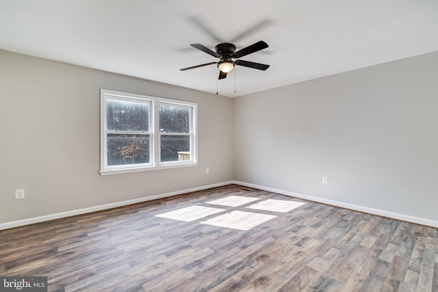 unfurnished room with a ceiling fan, baseboards, and wood finished floors