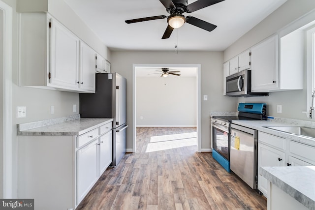 kitchen featuring stainless steel appliances, light countertops, and white cabinetry