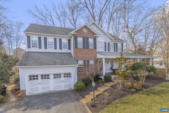 view of front of home with a garage, roof with shingles, covered porch, and driveway