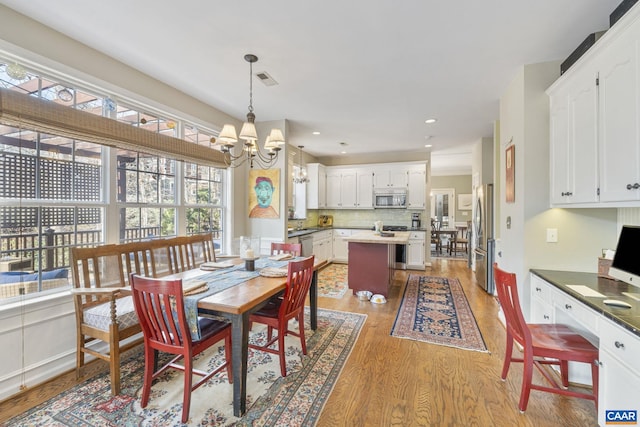 dining room featuring visible vents, light wood-style flooring, recessed lighting, baseboards, and a chandelier