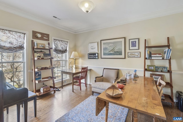 office area with visible vents, ornamental molding, and wood finished floors