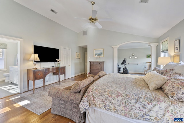 bedroom featuring visible vents, baseboards, wood finished floors, and ornate columns