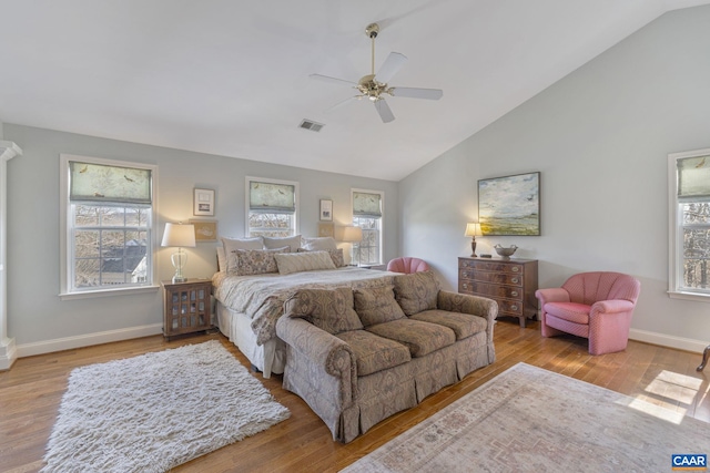 bedroom featuring wood finished floors, visible vents, baseboards, lofted ceiling, and ceiling fan