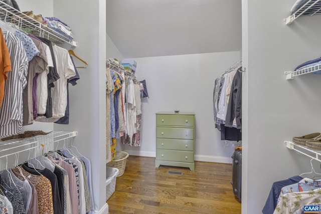 spacious closet featuring vaulted ceiling and wood finished floors