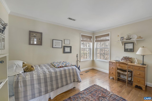 bedroom featuring visible vents, baseboards, hardwood / wood-style floors, and crown molding