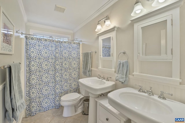 full bathroom with a shower with shower curtain, visible vents, wainscoting, crown molding, and toilet