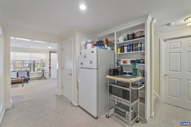 kitchen featuring carpet floors, ornamental molding, and freestanding refrigerator