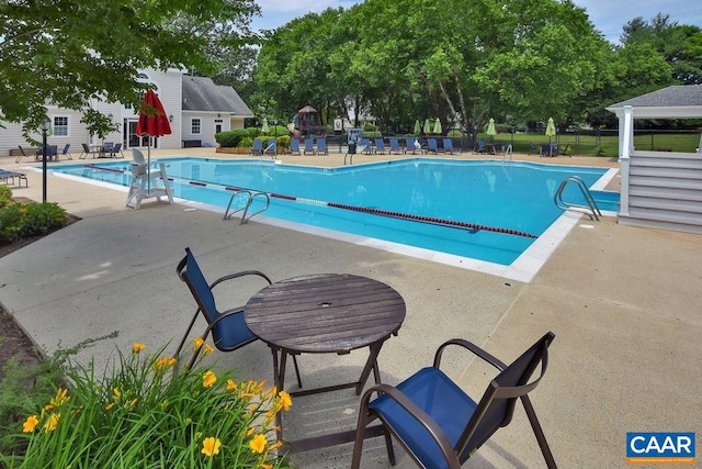 community pool with a patio and fence