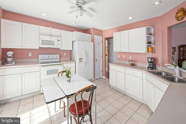 kitchen featuring a sink, white appliances, white cabinets, and light tile patterned floors