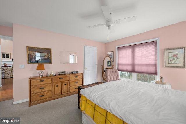 bedroom with baseboards, light colored carpet, and ceiling fan