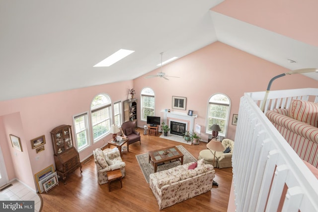 living area with plenty of natural light, a skylight, and wood finished floors