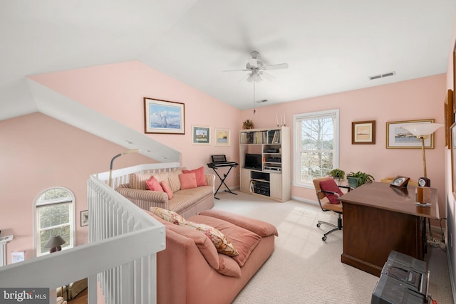 carpeted office space featuring lofted ceiling, a ceiling fan, and visible vents