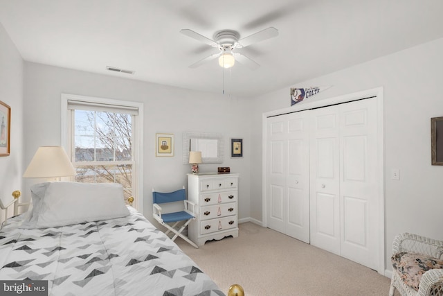 bedroom featuring visible vents, light colored carpet, a closet, and ceiling fan